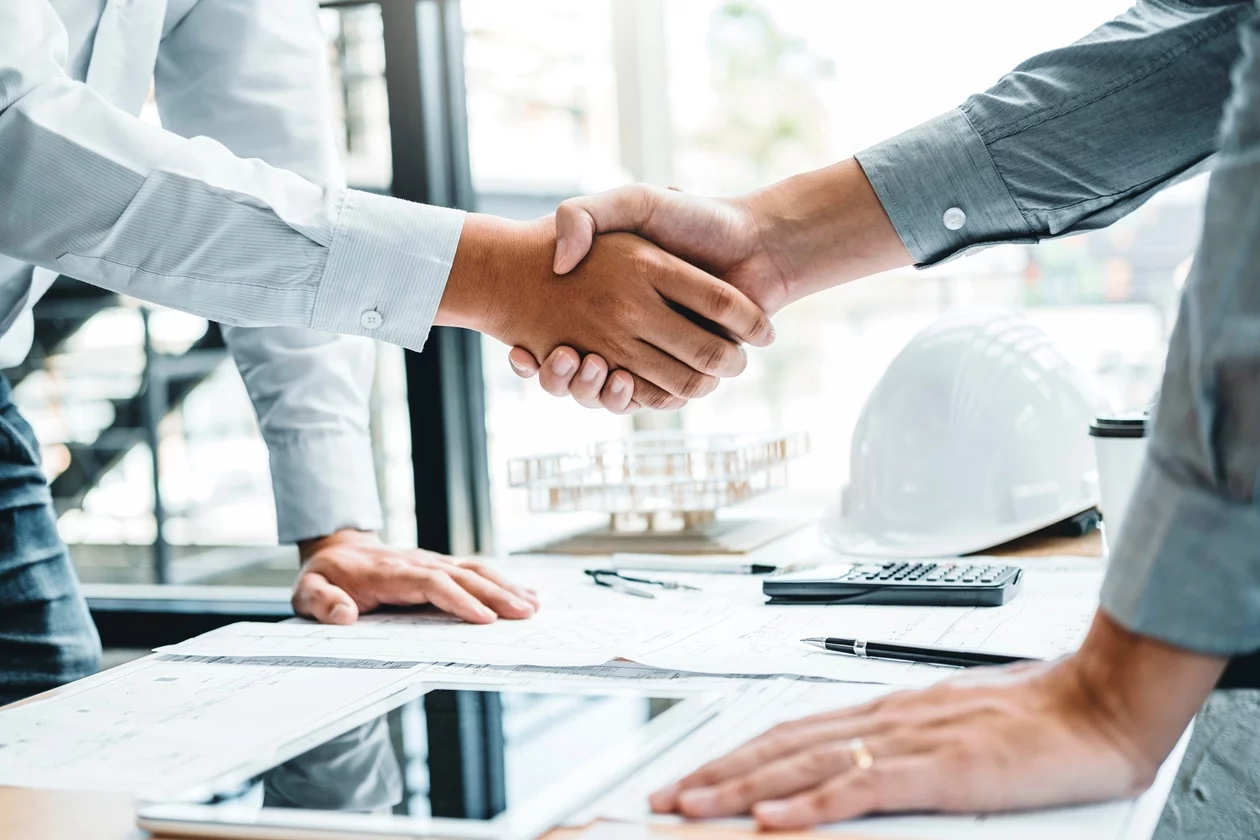 orderbase AddOns Microsoft Dynamics Partner Ingenieure begrüßen sich per Handschlag im Projektmeeting – Partnerschaftliche Zusammenarbeit und Add-on-Lösungen für erfolgreiche technische Projekte.